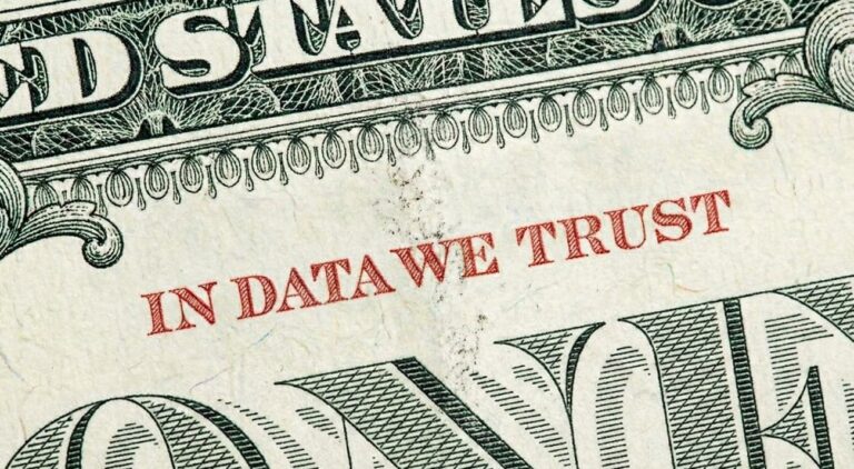 primer plano de un billete de dolar con la frase "in data we trust" escrita en rojo